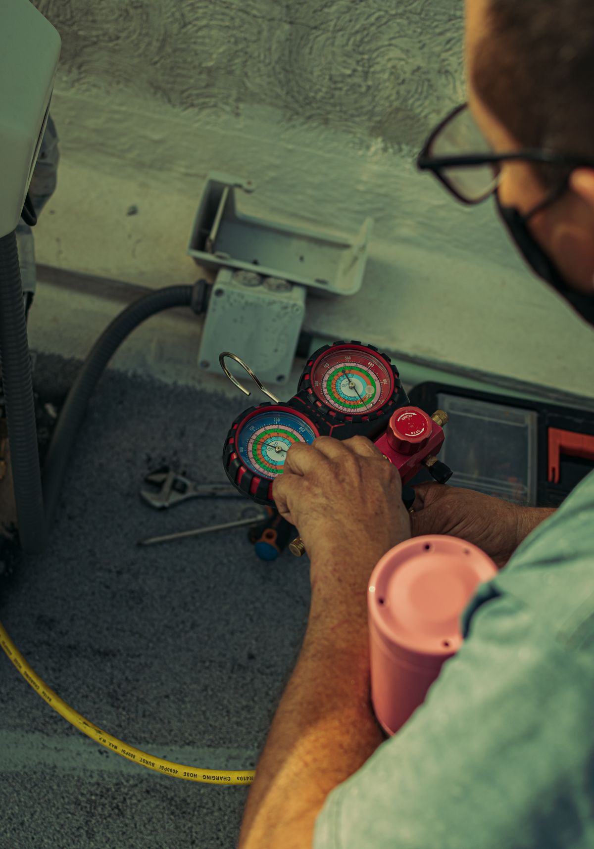 Técnico profesional midiendo presión de refrigerante en aire acondicionado