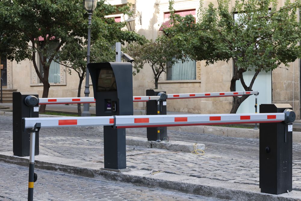 Talanqueras automáticas con brazo rojo y blanco en un acceso vehicular